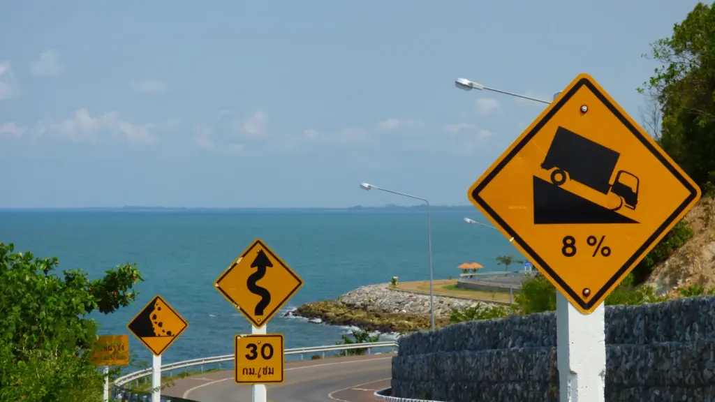 Steep and winding coastal road signs at Noen Nang Phaya viewpoint in Chanthaburi